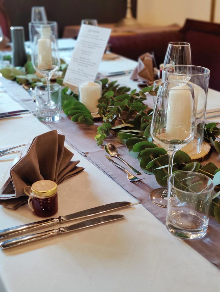 Tischdekoration mit Blumen, Kerzen und personalisierten Geschenken