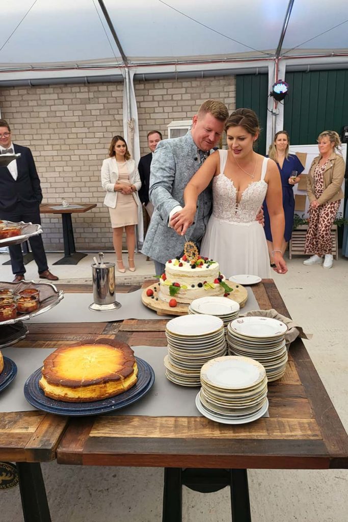 Ein Hochzeitspaar schneidet die Torte an