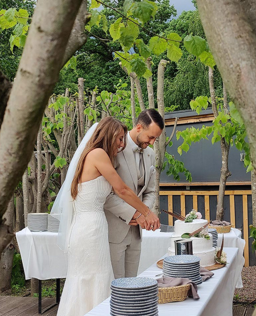 Ein Hochzeitspaar schneidet die Torte an